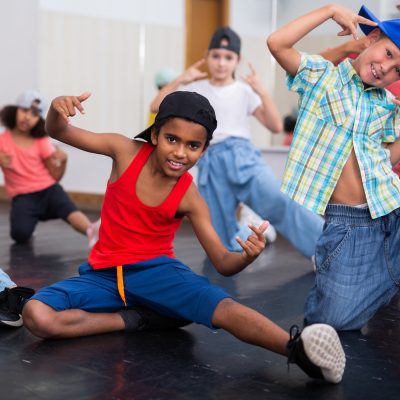 Positive girls and boys training hip hop in dance studio, dance classes for kids